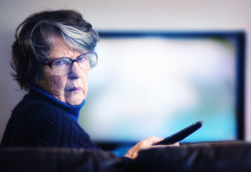Old woman failing to master TV remote turns away frustrated