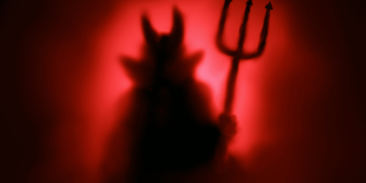 Creepy devil silhouette on red background