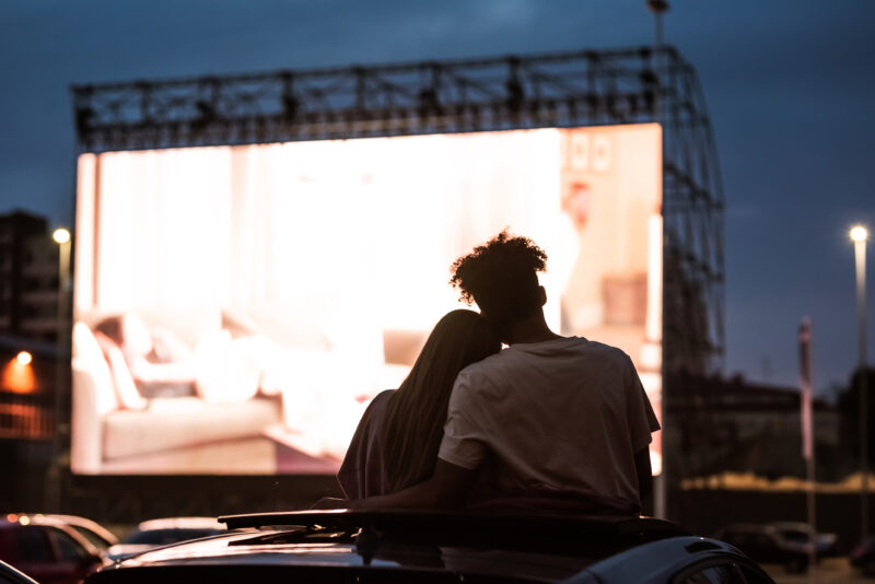 Silhouetted view of couple at a drive in cinema