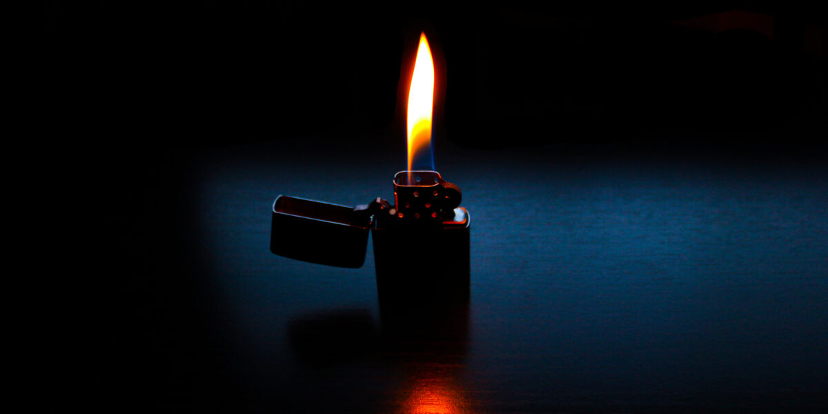 Gasoline lighter on a table in a dark room