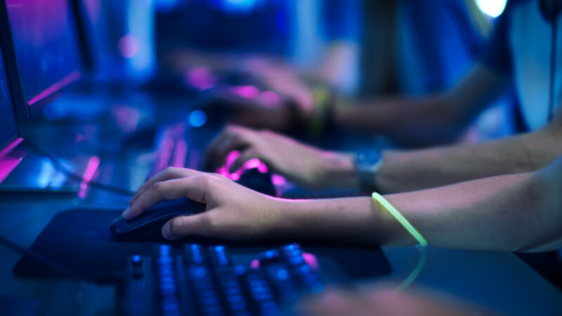 Close-up of a row of gamer's hands actively pushing buttons