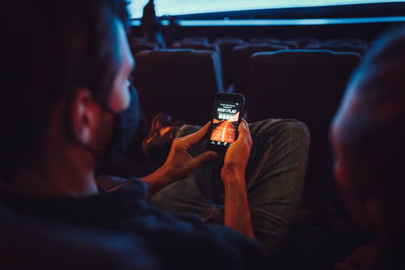 Man in cinema looking at Redyplay on his phone