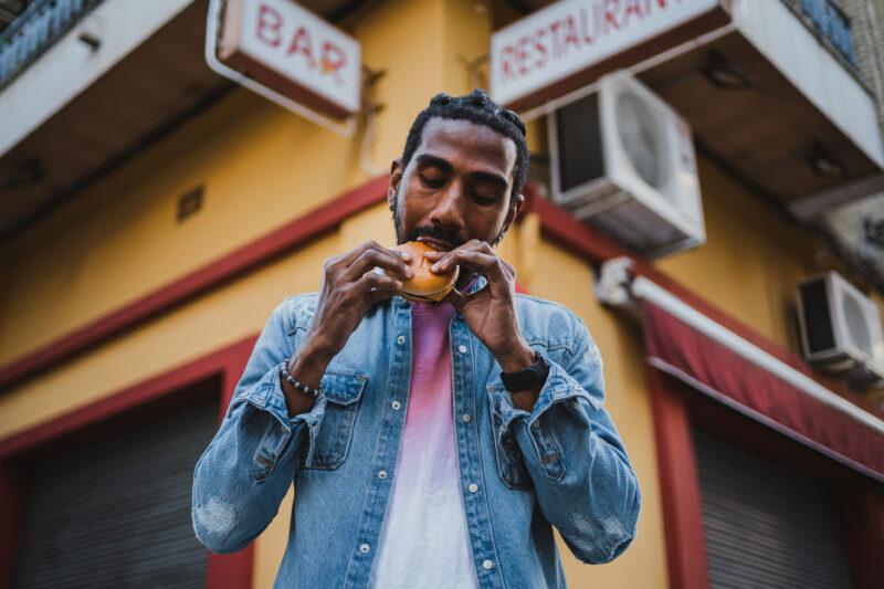 Young man eating a cheeseburger